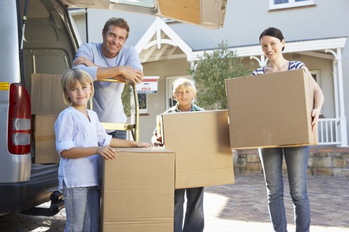 Movers carrying furniture down stairs in a Lewisham flat